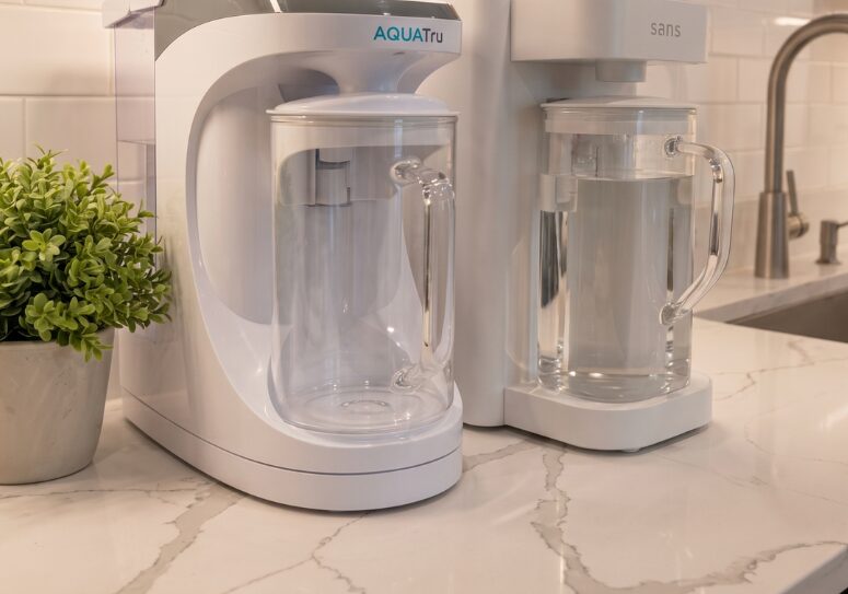 AquaTru Carafe and Sans Water Purifier side by side on the counter